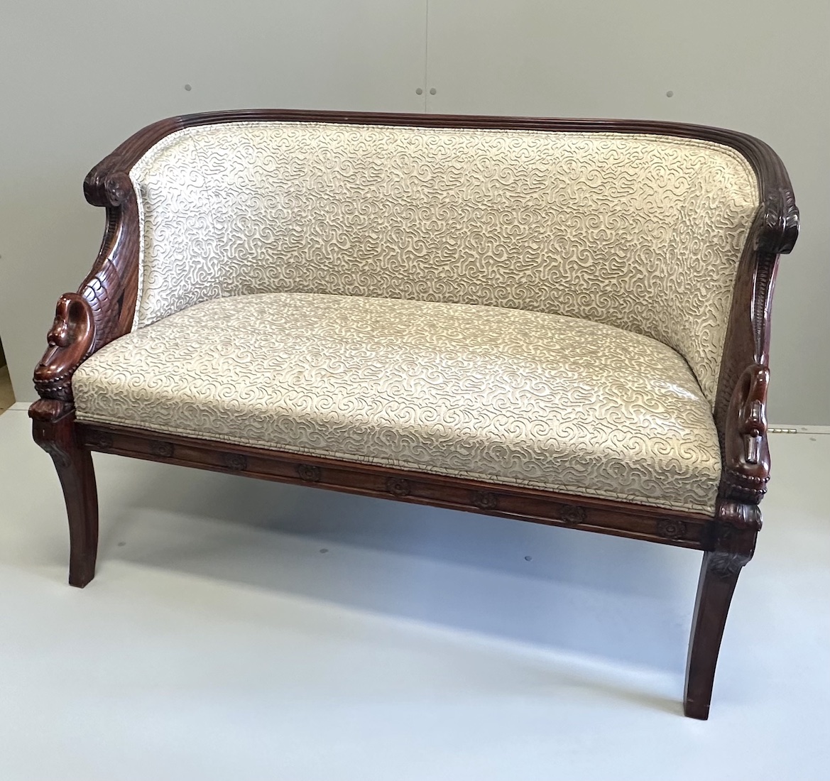 A small Regency style mahogany settee, the reeded frame with swans heads end scrolls, width 125cm, depth 64cm, height 85cm